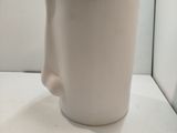 une tasse à café blanche posée sur une table blanche