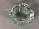 a clear glass ashtray with a small hole in the middle