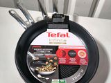 a frying pan hanging on the wall with a tag on it