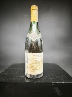 une vieille bouteille de vin posée sur une table noire
