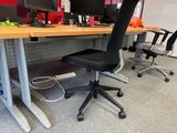 a desk with two computer monitors on it and a chair in front of it