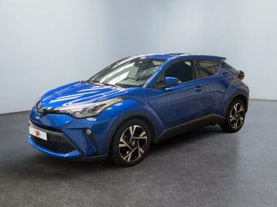 un SUV Toyota C-HR bleu garé dans une pièce blanche