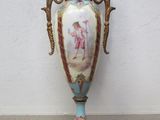 un vase posé sur un socle et orné d'une image représentant une femme