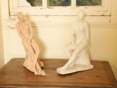 deux statues posées sur une table près d'une fenêtre