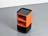 an orange and black shelf on a gray floor