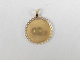 a close up of a gold pendant on a white surface