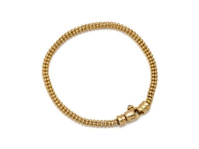 un bracelet en perles dorées muni d'un fermoir à boule, sur fond blanc