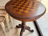 une table sur laquelle est posé un échiquier, devant une fenêtre