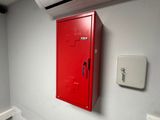 a red locker on the wall next to a toilet