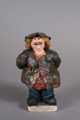 une figurine représentant un homme portant un chapeau et une veste