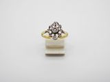 a gold and white diamond ring on a white surface