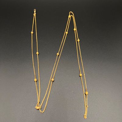 une paire de colliers plaqués or sur fond noir