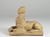 statue of a woman laying on a pillow on a white surface