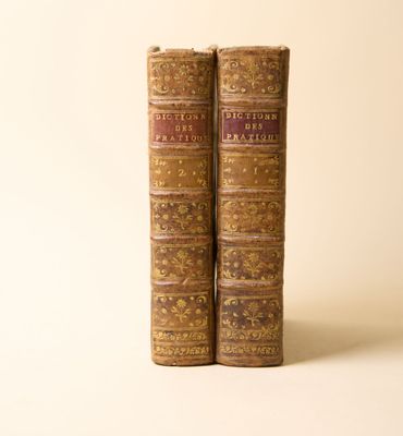 deux vieux livres posés l'un sur l'autre sur une surface blanche