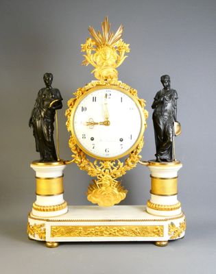 a clock with a statue of a man and a woman on top of it
