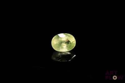 a close up of a green gemstone on a black surface