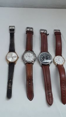 plusieurs types de montres sont alignés sur une surface blanche