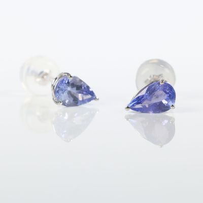 une paire de boucles d'oreilles en tanzanite et en or blanc sur un fond blanc