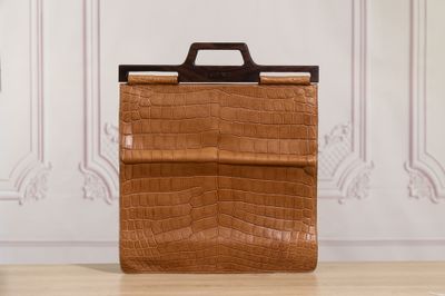 an image of a brown briefcase sitting on top of a wooden floor