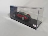 a red car in a clear display case on a white surface