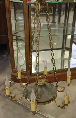 a chandelier with candles and a glass case in the background