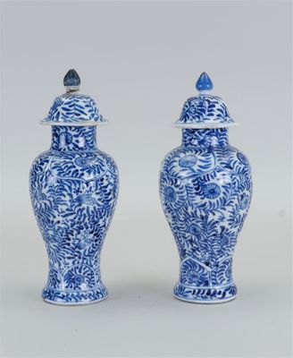une paire de vases bleus et blancs surmontés d'oiseaux