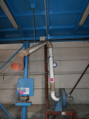 une photo d'une pièce avec des tuyaux et un plafond bleu