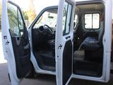 a white van with its doors open and a yellow truck in the background