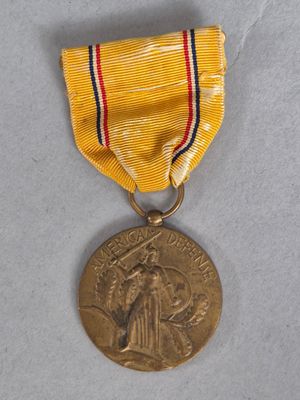 une vieille médaille entourée d'un ruban, posée sur une surface blanche