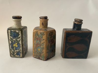 three small bottles sitting next to each other on a white surface