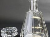 a glass bottle and a glass stopper sitting on a table