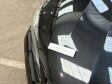 a sticker on the hood of a car that is parked in a parking lot