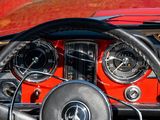 steering wheel and dashboard of a classic car with a red interior