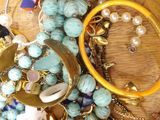 a wooden bowl filled with assorted jewelry on a table