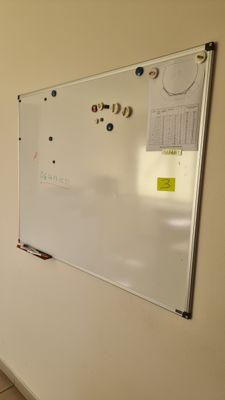 un tableau blanc accroché au mur d'une pièce