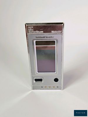 un petit appareil électronique posé sur une surface blanche