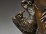 bronze statue of a woman holding a bird and a bird in her hand