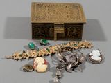a gold box with a bunch of jewelry on it