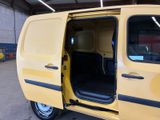 a yellow van with its door open in a garage