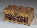 une boîte en bois richement décorée, munie d'une serrure, posée sur une surface blanche