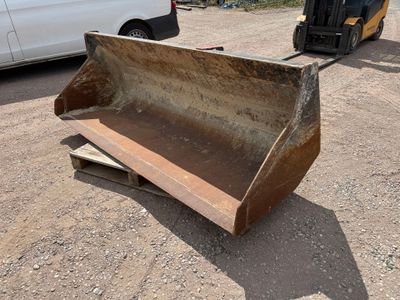 un bulldozer posé au sol à côté d'une camionnette blanche