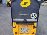 a small yellow and black vehicle parked in a parking lot