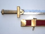 pair of swords with red and gold accents on a white surface