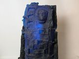 a sculpture of a building with a blue light on it