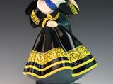 an image of a figurine of a woman in a black and yellow dress