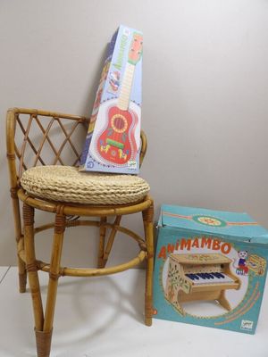 a small chair with a guitar on it next to a box of music