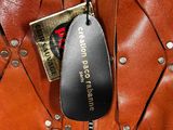 a brown leather bag with a black tag on it