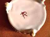 a small white plate with a red design on it