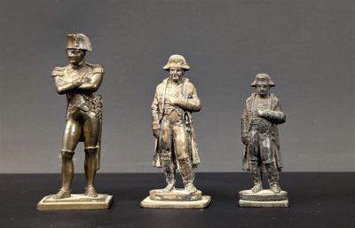 trois figurines en bronze représentant un homme et une femme debout l'un à côté de l'autre