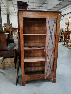 un meuble en bois avec une porte en verre au milieu d'une pièce